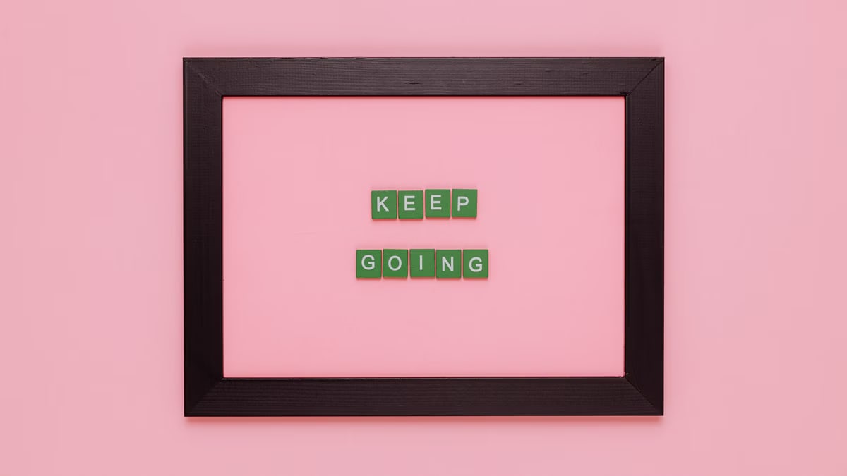A framed motivational quote on a pink background for inspiration.